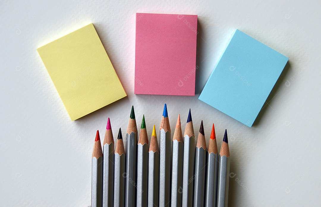 Três adesivos post it em branco e lápis coloridos