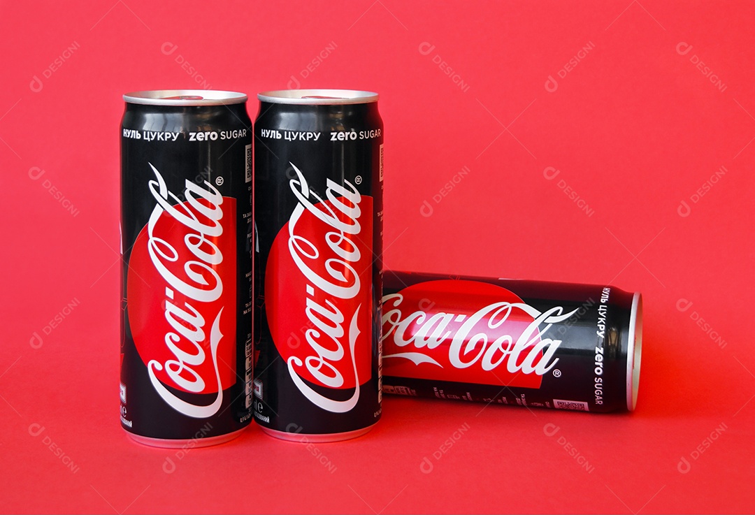 Três latas de coca cola light sobre fundo vermelho