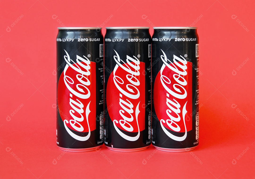 Três latas de coca cola light sobre fundo vermelho