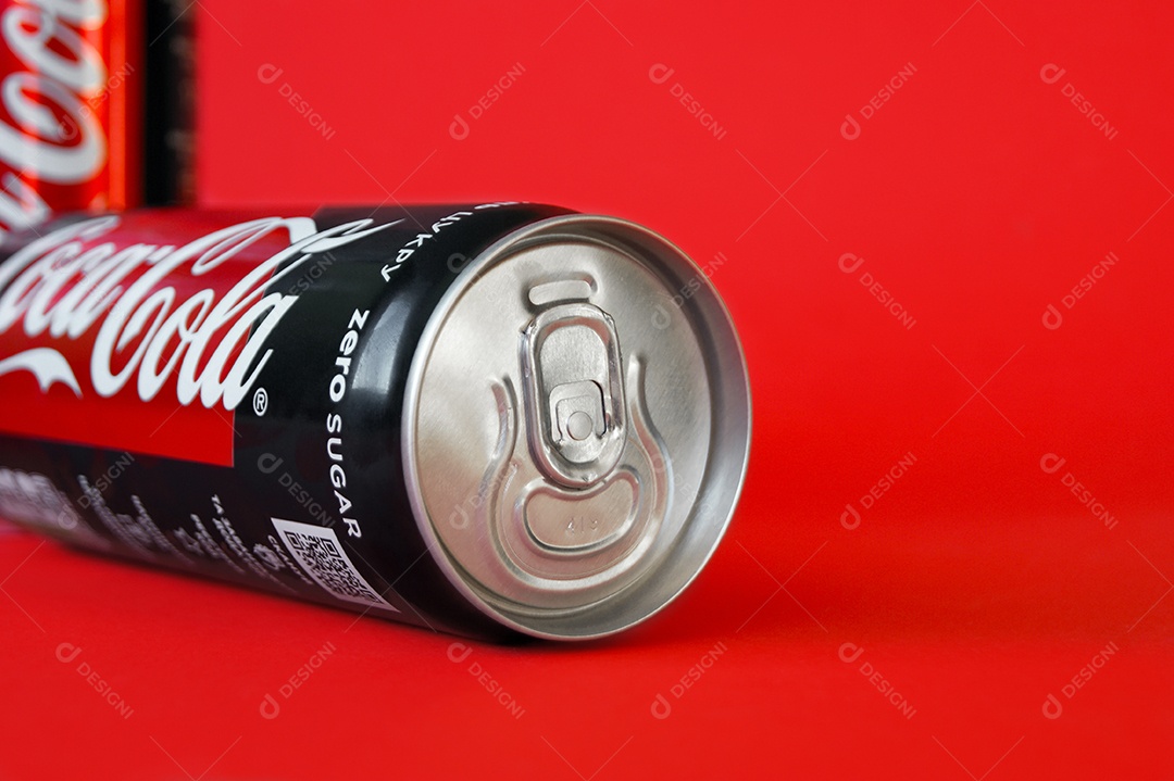 Latas de coca cola palito light lacradas sobre fundo vermelho