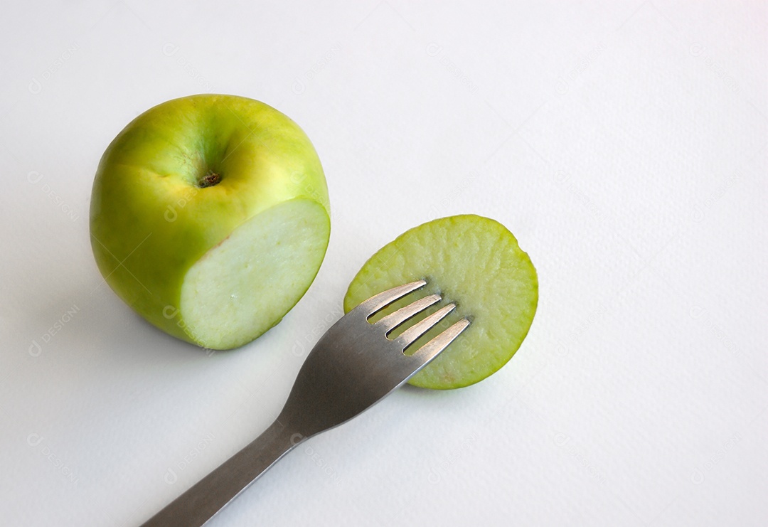 Maçã verde cortada e garfo em pedaço