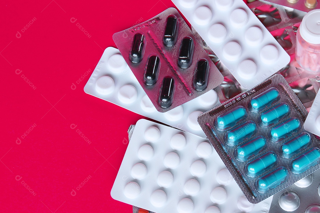 Cartelas de remédios e capsulas em fundo vermelho