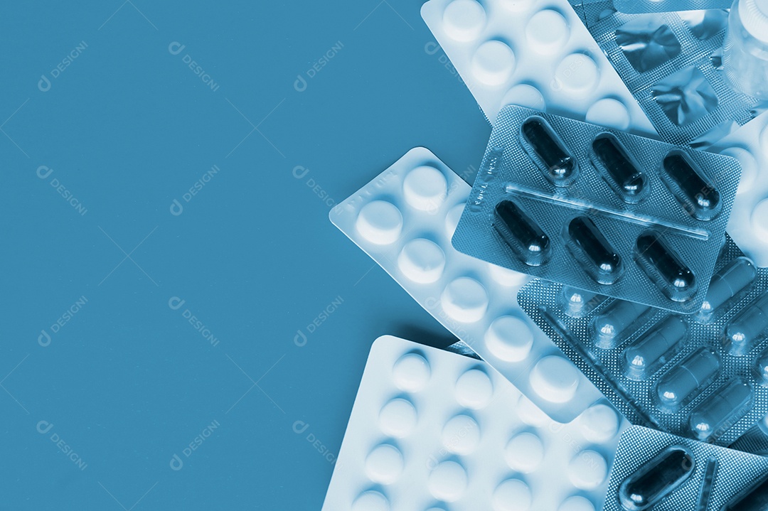 Vários remédios comprimidos capsulas sobre fundo azul