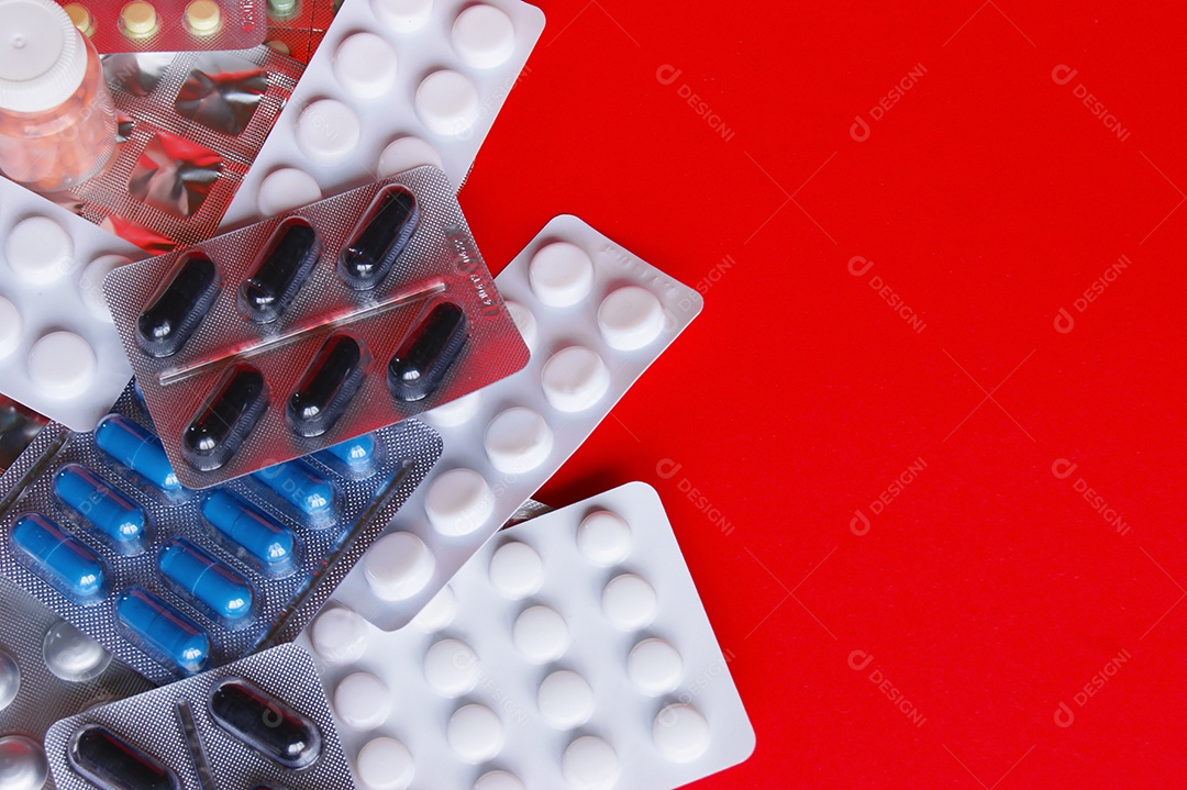 Cartelas de remédios e capsulas em fundo vermelho