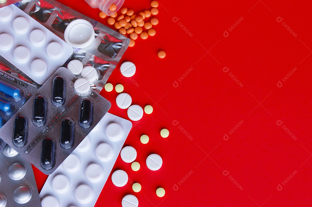 Vários remédios comprimidos capsulas sobre fundo vermelho