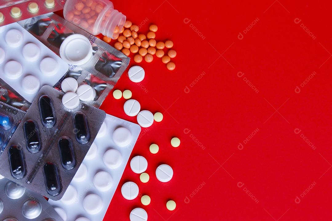 Vários remédios comprimidos capsulas sobre fundo vermelho