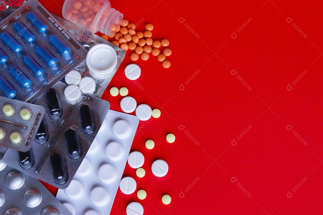 Vários remédios comprimidos capsulas sobre fundo vermelho