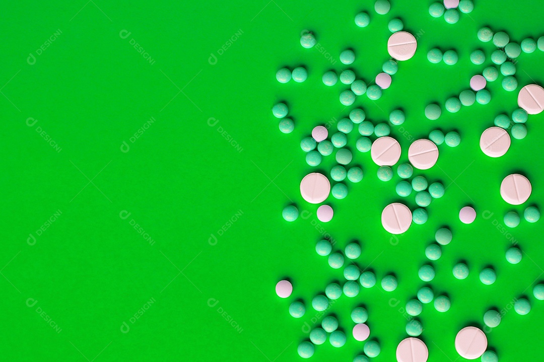 Remédios e comprimidos espalhados sobre fundo verde