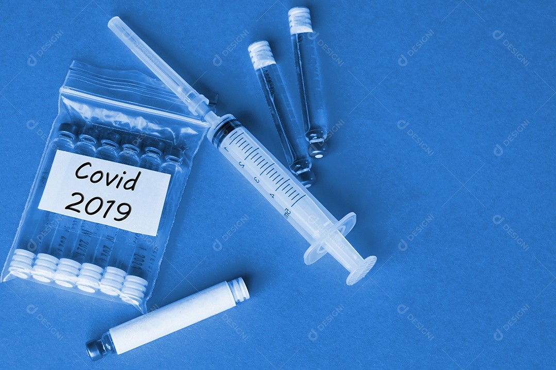 Seringa e ampolas com vacina contra o vírus sobre fundo isolado vermelho