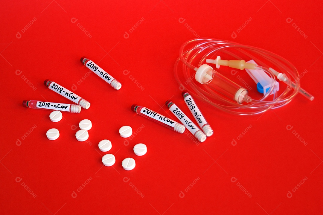 Tubos coletores e cateter e comprimidos sobre fundo vermelho