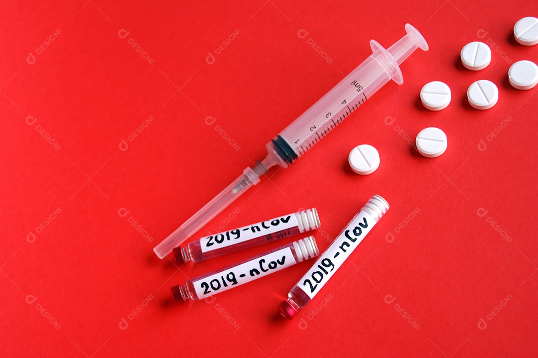 Tubos coletores seringa com agulha e comprimidos sobre fundo vermelho