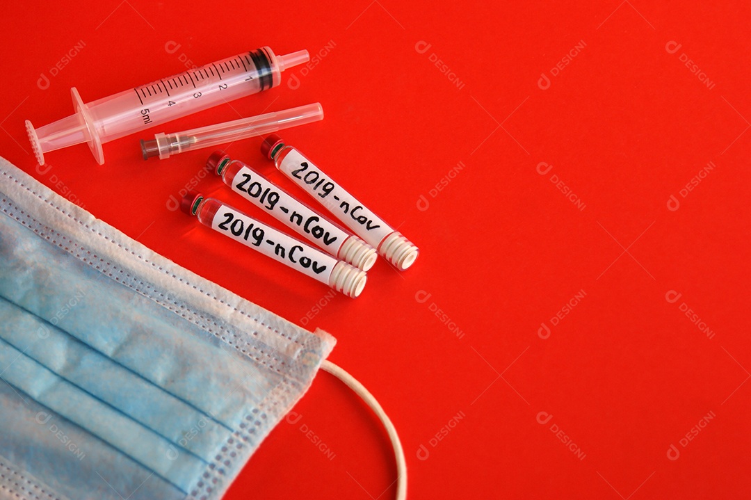 Máscara seringa agulhas e tubos coletores sobre fundo vermelho