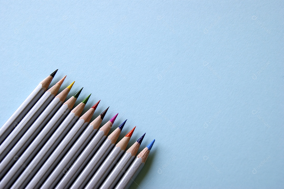 Lápis de cor coloridos sobre fundo azul