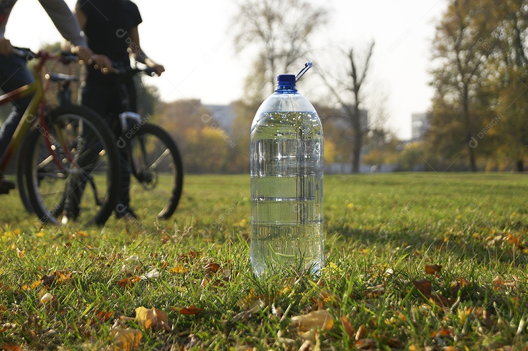 Garrafa de água e dois ciclista em parque de natureza