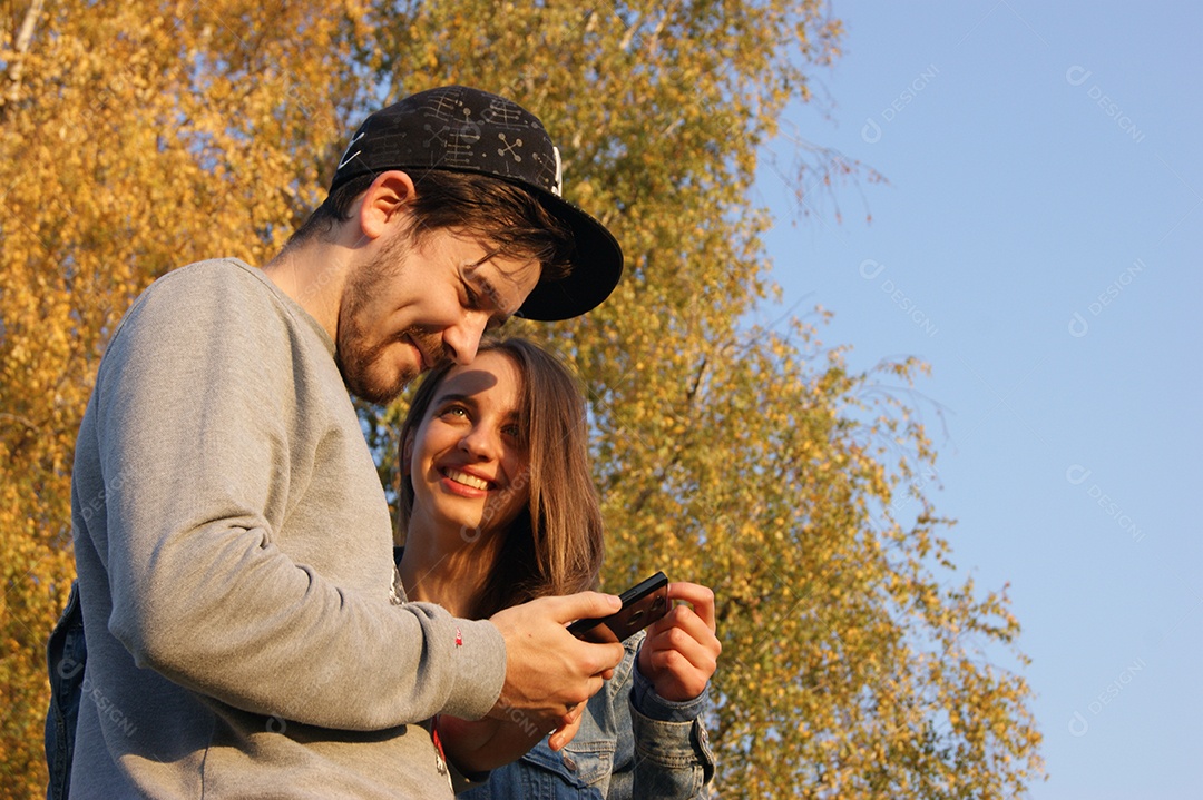 Lindo casal feliz olhando celular