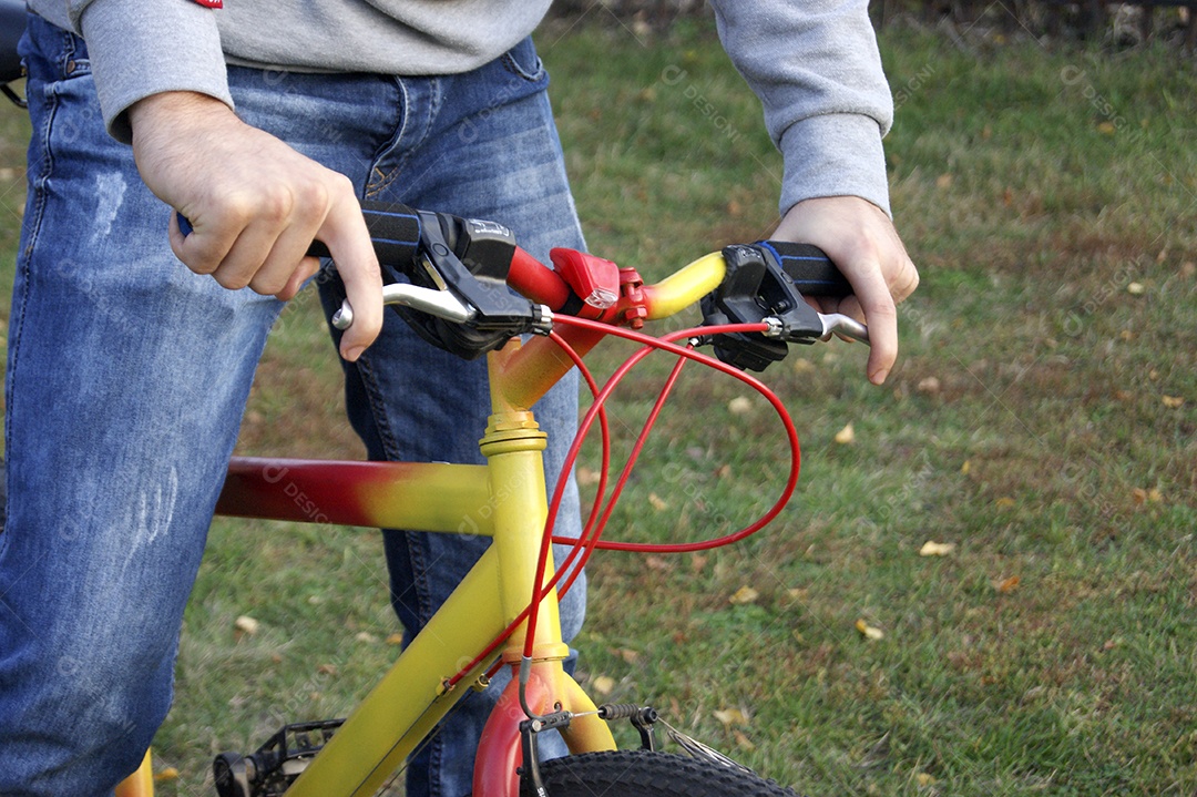 Jovem está andando de bicicleta em um parque