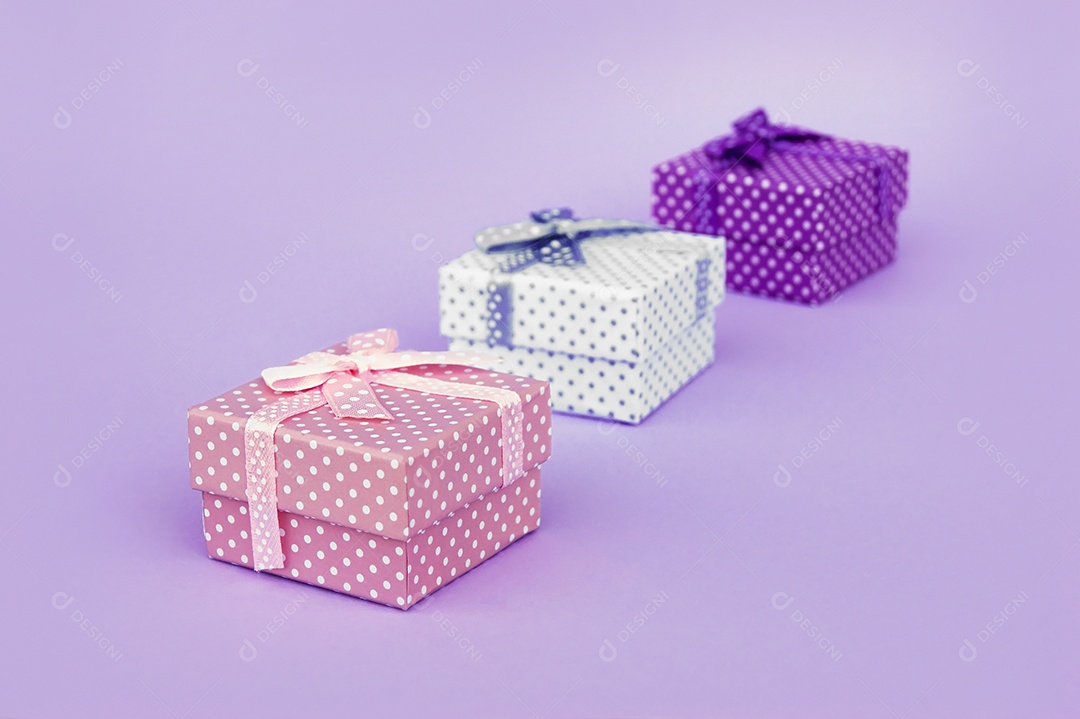 Tr~es caixa de presente em filas sobre fundo roxo