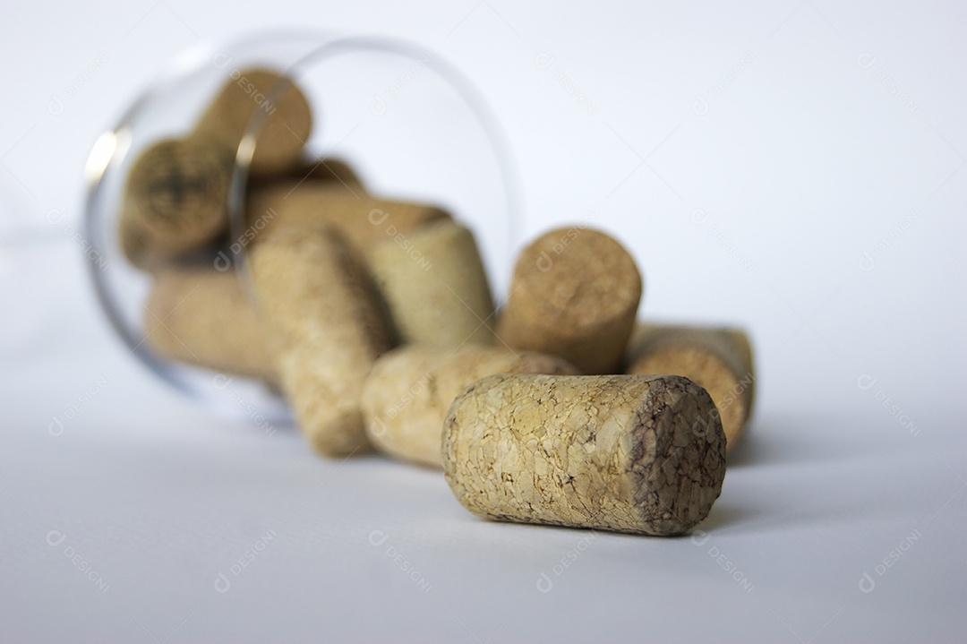 Taça virada com muitas rolhas de produtores diferentes de vinhos