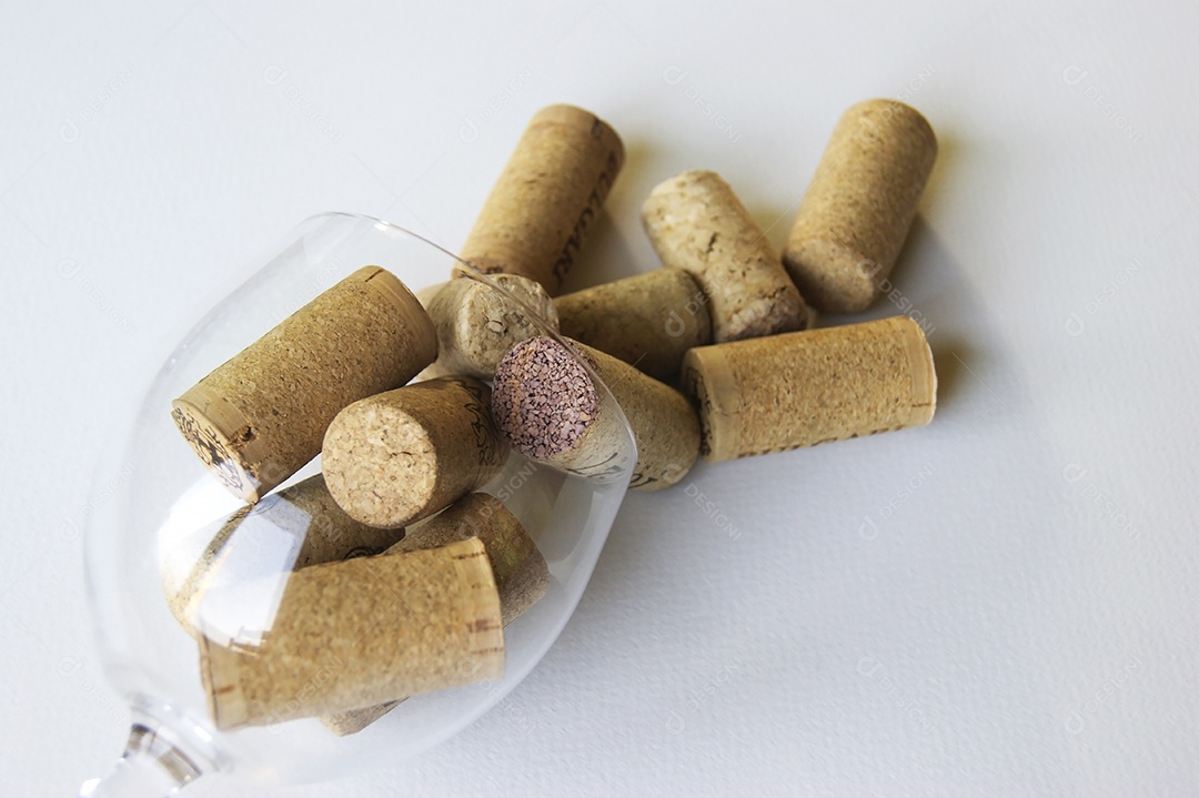 Taça virada com muitas rolhas de produtores diferentes de vinhos