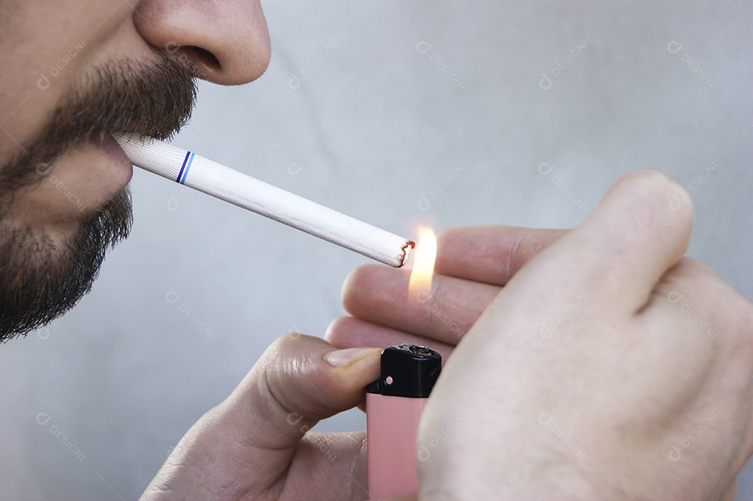 Jovem de barba acendendo cigarro para fumar