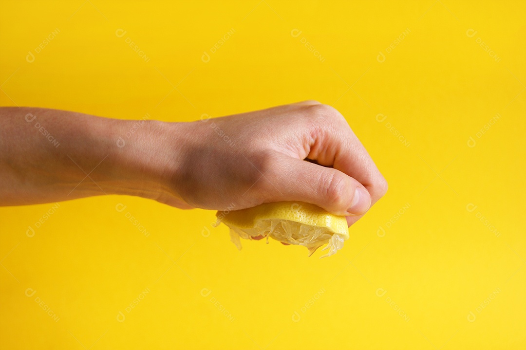 A mão esmaga um pedaço de limão fresco