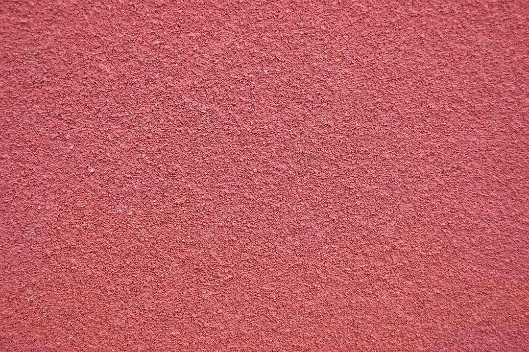 A parede horizontal vermelha coberta com textura de gesso