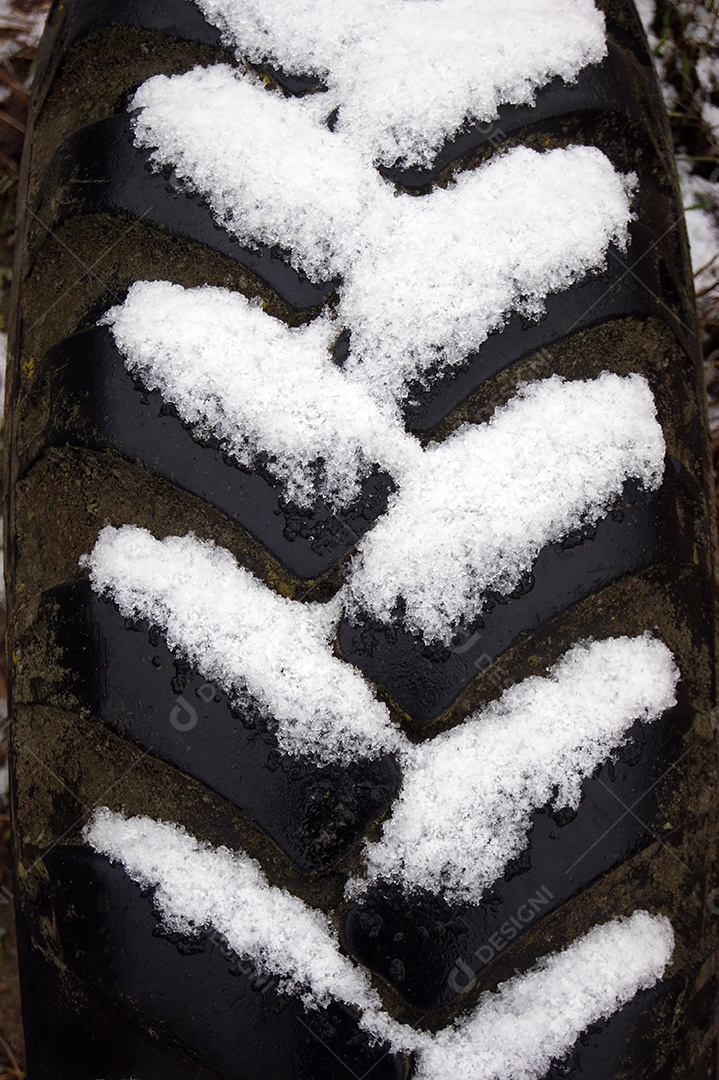 A textura de um pneu velho com neve nas ranhuras