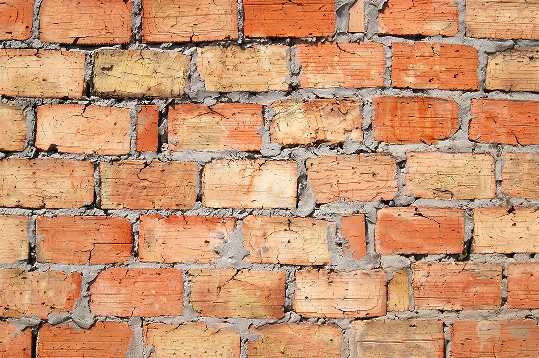 Parede de tijolos alaranjados com cimento sem reboco