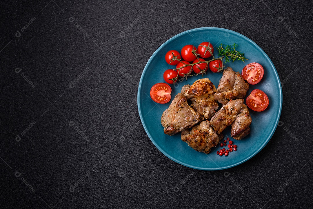 Delicioso espetinho frito de frango ou carne de porco com sal, especiarias e ervas sobre um fundo escuro de concreto