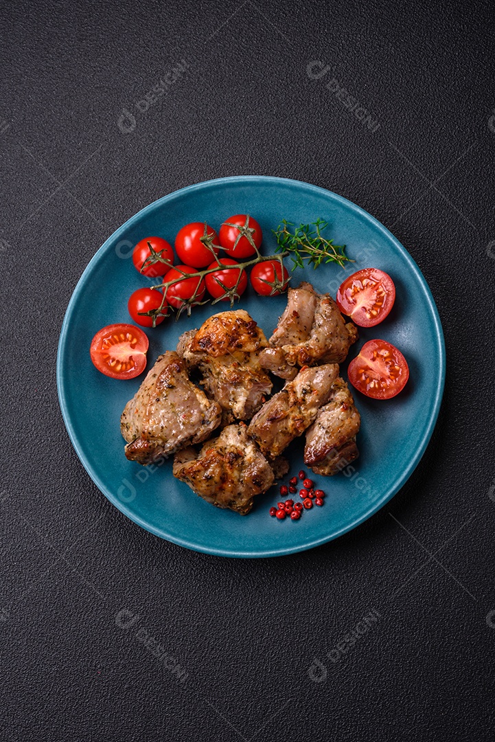 Delicioso espetinho frito de frango ou carne de porco com sal, especiarias e ervas sobre um fundo escuro de concreto