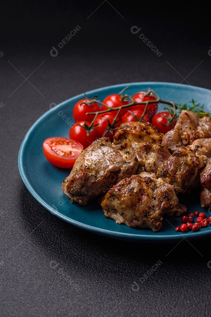 Delicioso espetinho frito de frango ou carne de porco com sal, especiarias e ervas sobre um fundo escuro de concreto