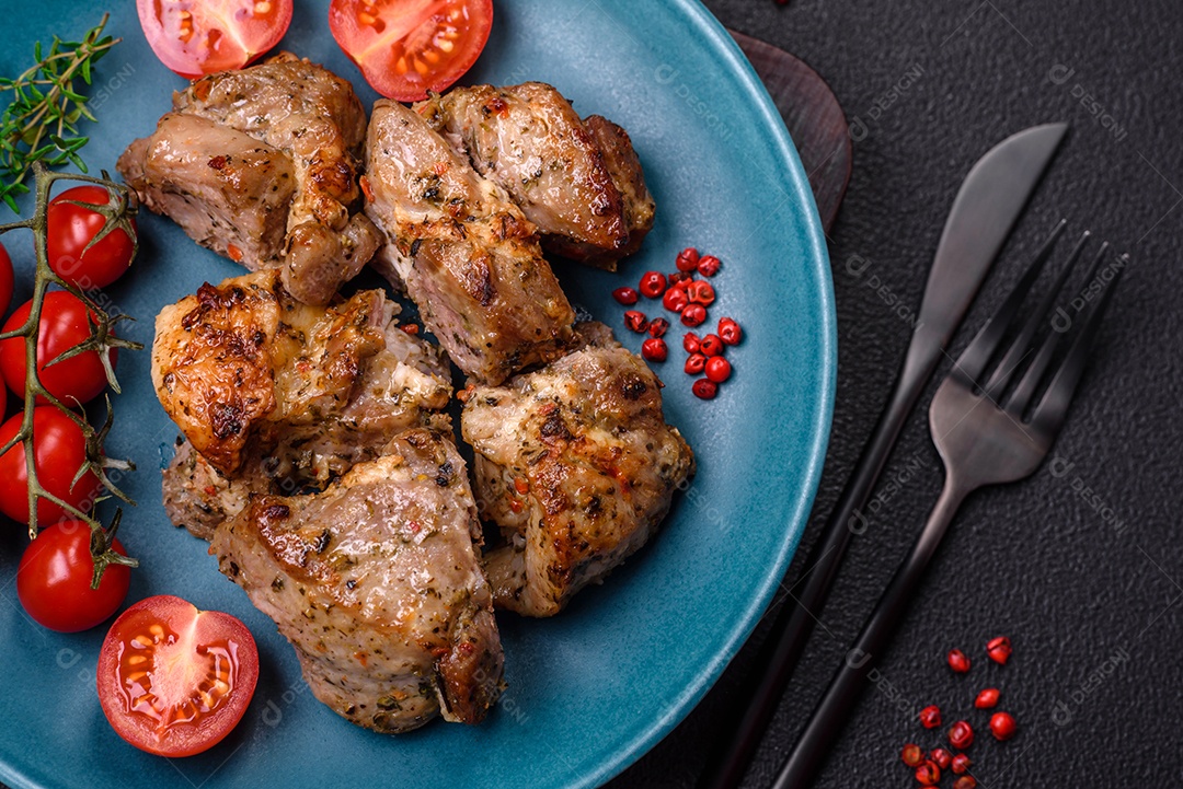 Delicioso espetinho frito de frango ou carne de porco com sal, especiarias e ervas sobre um fundo escuro de concreto