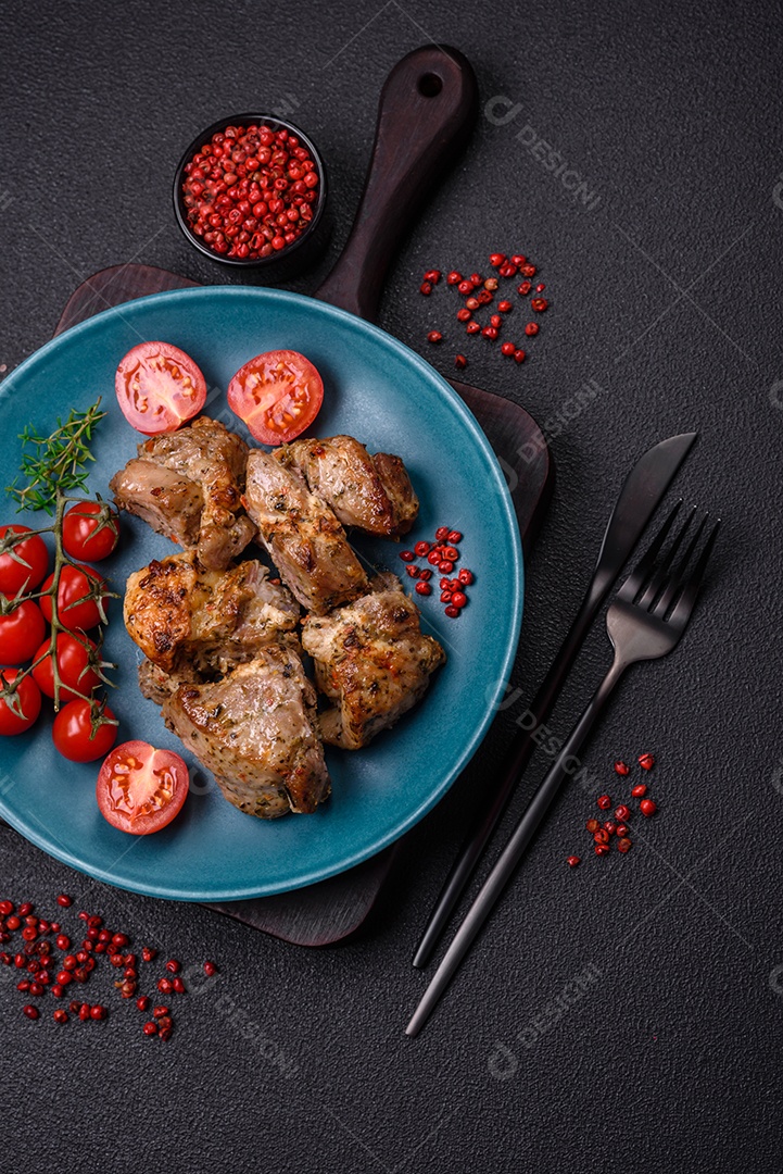 Delicioso espetinho frito de frango ou carne de porco com sal, especiarias e ervas sobre um fundo escuro de concreto