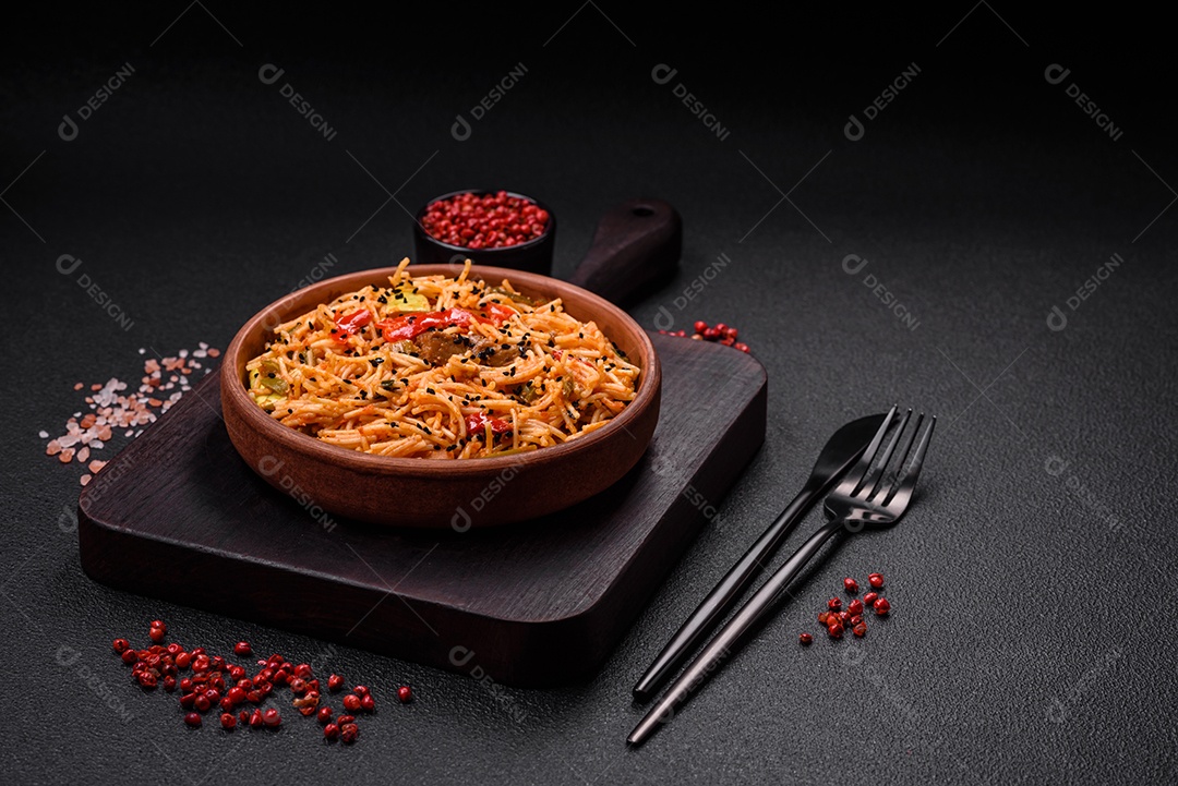 Delicioso macarrão udon com carne ou frutos do mar, legumes, sal e especiarias sobre um fundo escuro de concreto