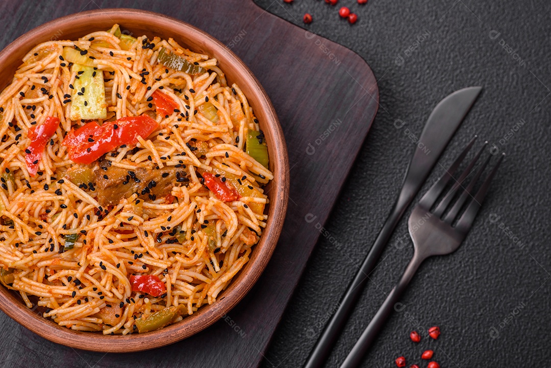 Delicioso macarrão udon com carne ou frutos do mar, legumes, sal e especiarias sobre um fundo escuro de concreto
