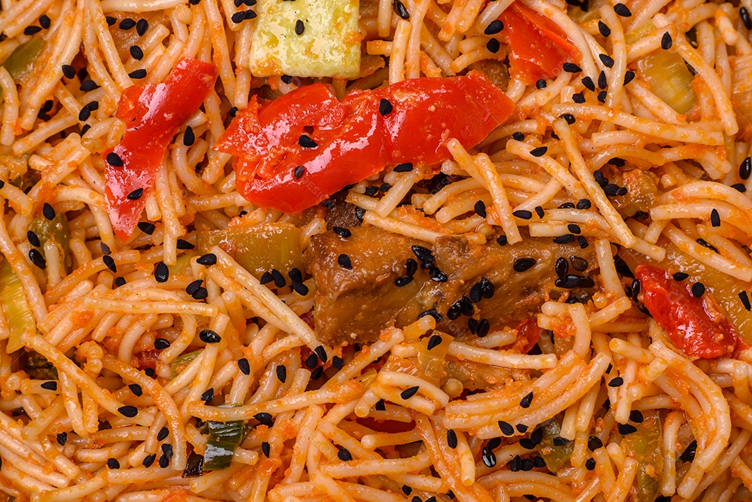Delicioso macarrão udon com carne ou frutos do mar, legumes, sal e especiarias sobre um fundo escuro de concreto