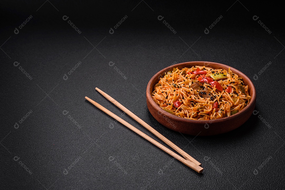Delicioso macarrão udon com carne ou frutos do mar, legumes, sal e especiarias sobre um fundo escuro de concreto