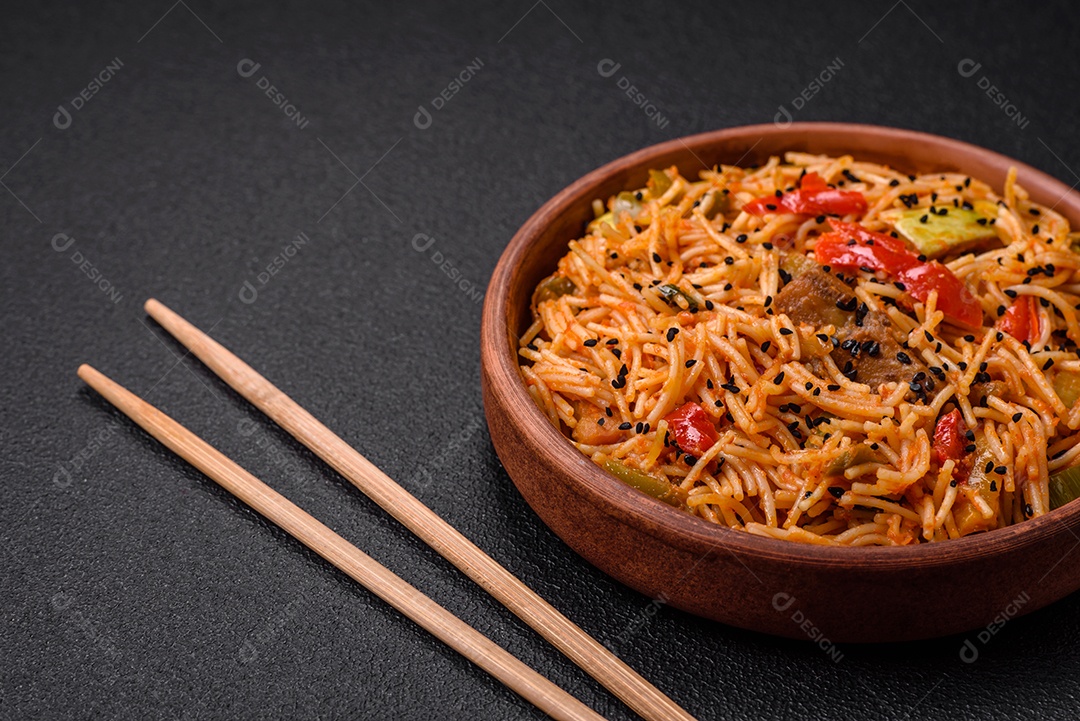 Delicioso macarrão udon com carne ou frutos do mar, legumes, sal e especiarias sobre um fundo escuro de concreto