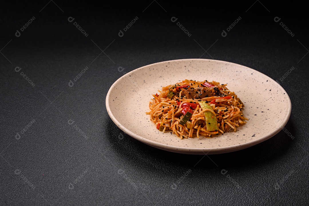 Delicioso macarrão udon com carne ou frutos do mar, legumes, sal e especiarias sobre um fundo escuro de concreto