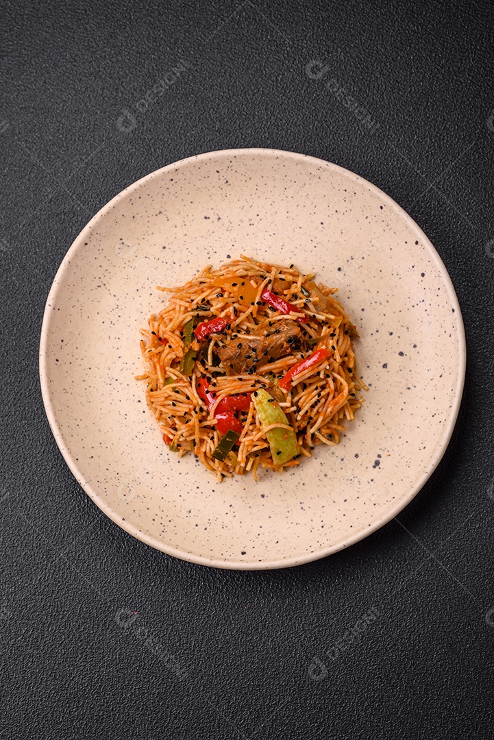 Delicioso macarrão udon com carne ou frutos do mar, legumes, sal e especiarias sobre um fundo escuro de concreto