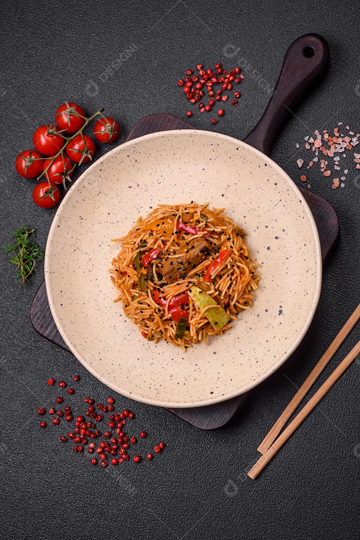 Delicioso macarrão udon com carne ou frutos do mar, legumes, sal e especiarias sobre um fundo escuro de concreto