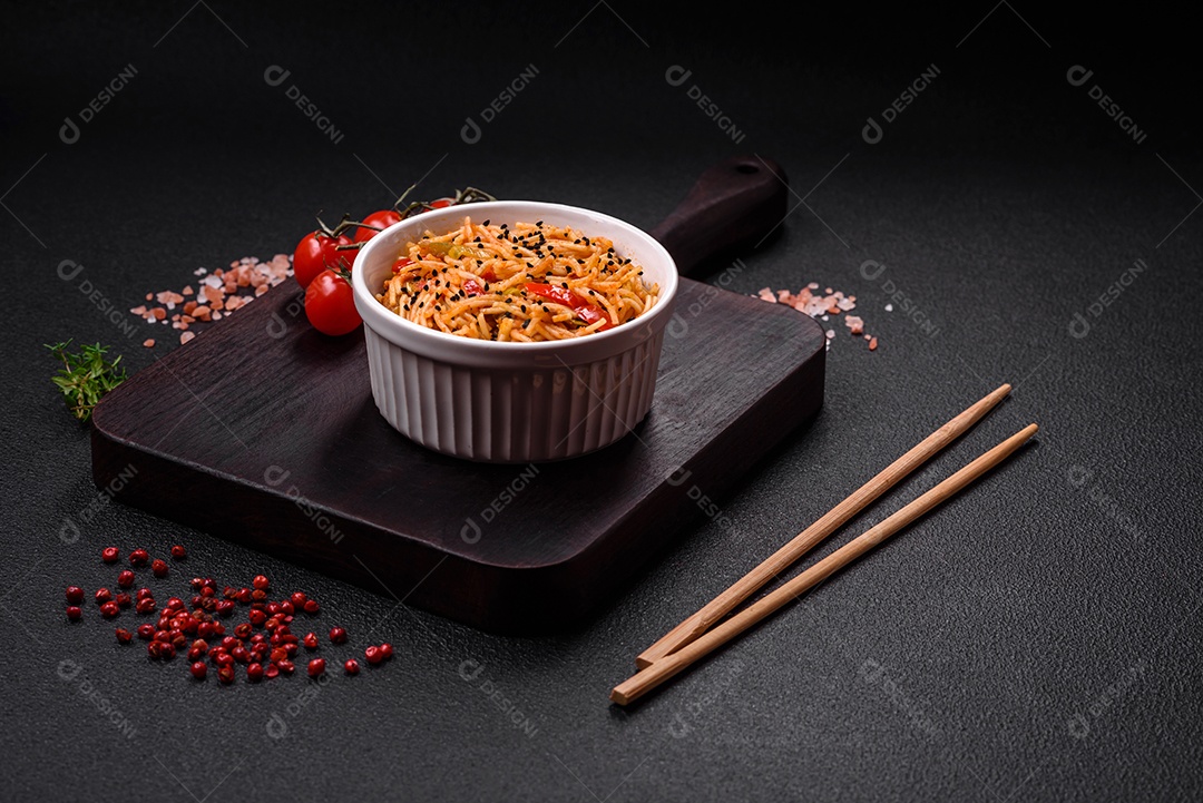Delicioso macarrão udon com carne ou frutos do mar, legumes, sal e especiarias sobre um fundo escuro de concreto