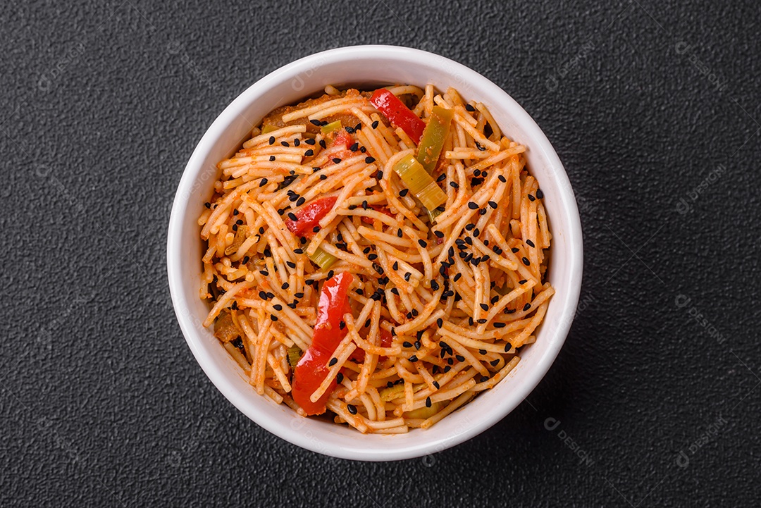 Delicioso macarrão udon com carne ou frutos do mar, legumes, sal e especiarias sobre um fundo escuro de concreto