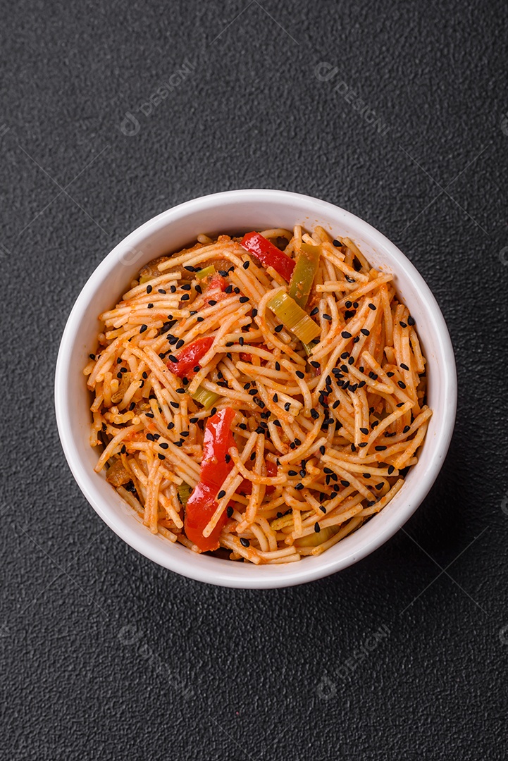 Delicioso macarrão udon com carne ou frutos do mar, legumes, sal e especiarias sobre um fundo escuro de concreto