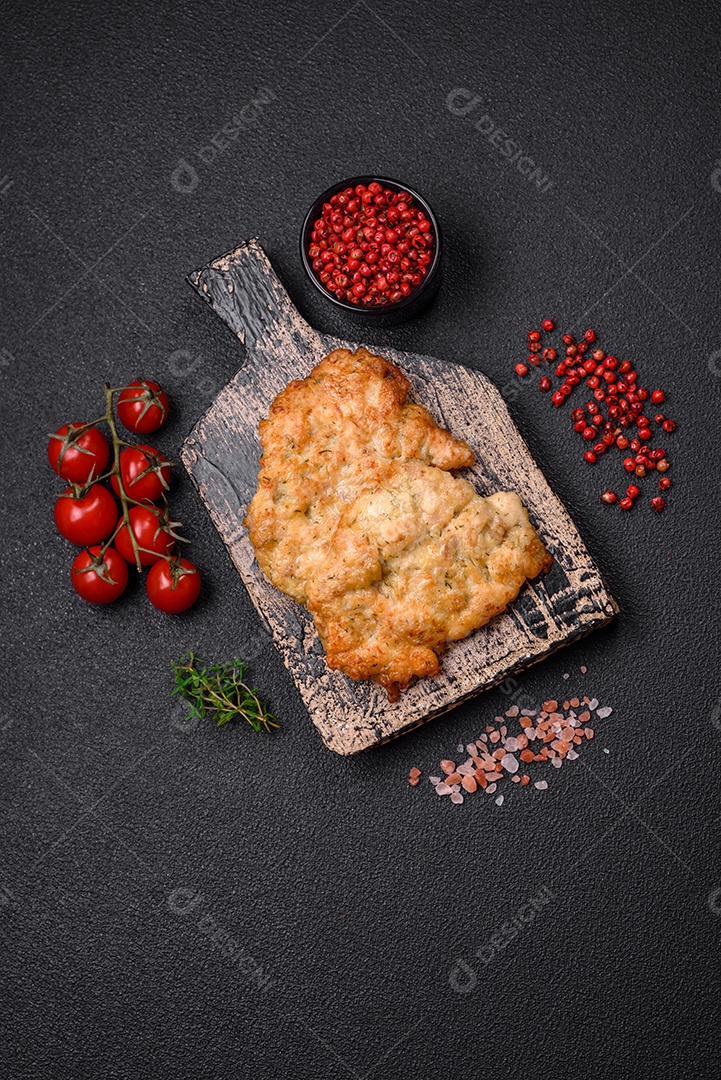 Deliciosas costeletas de frango ou peru assadas com sal, especiarias e ervas sobre um fundo escuro de concreto