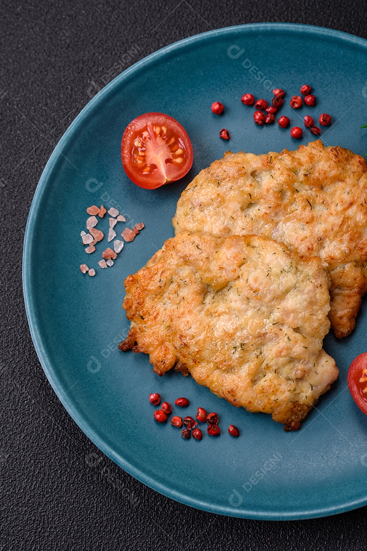 Deliciosas costeletas de frango ou peru assadas com sal, especiarias e ervas sobre um fundo escuro de concreto