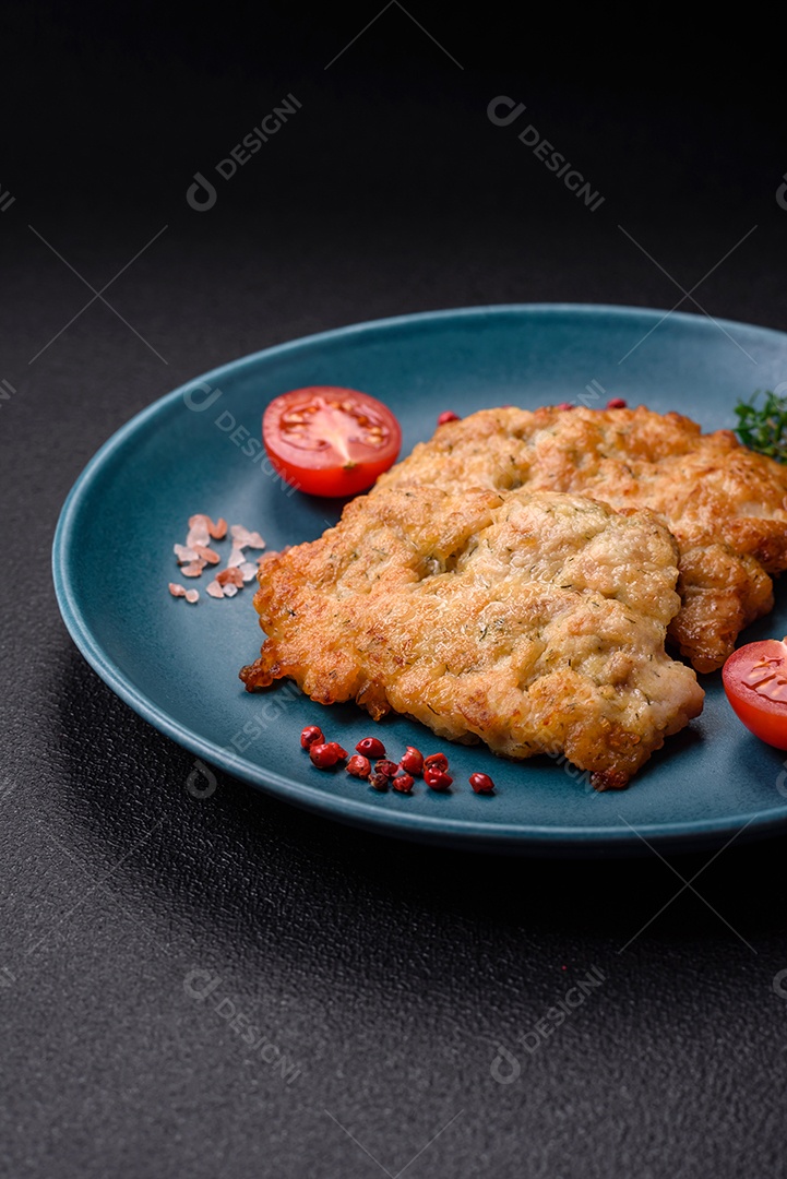 Deliciosas costeletas de frango ou peru assadas com sal, especiarias e ervas sobre um fundo escuro de concreto