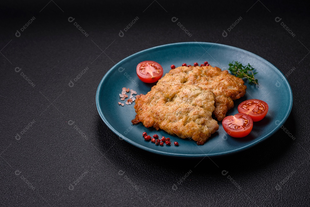 Deliciosas costeletas de frango ou peru assadas com sal, especiarias e ervas sobre um fundo escuro de concreto