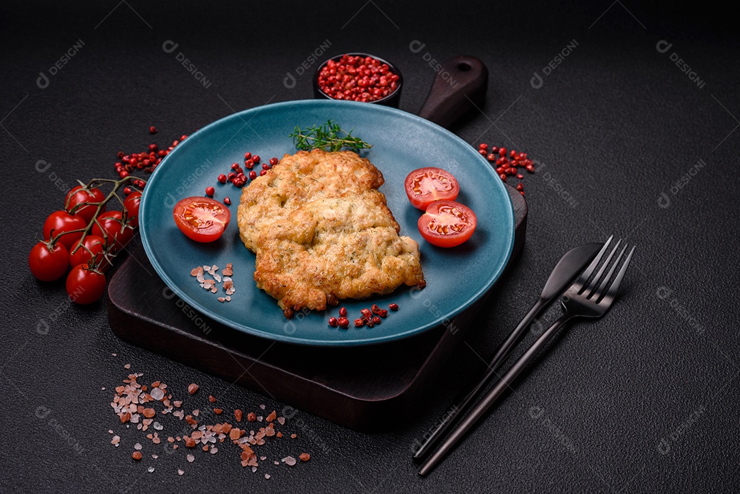 Deliciosas costeletas de frango ou peru assadas com sal, especiarias e ervas sobre um fundo escuro de concreto