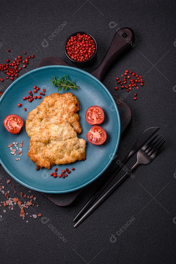 Deliciosas costeletas de frango ou peru assadas com sal, especiarias e ervas sobre um fundo escuro de concreto